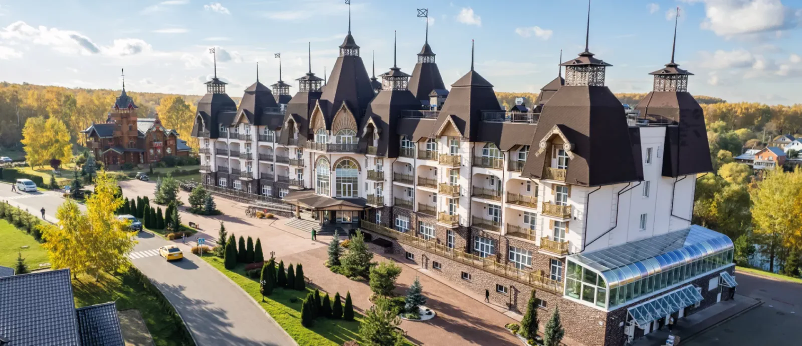 Корпус парк-отеля Орловский с башенками среди осеннего леса
